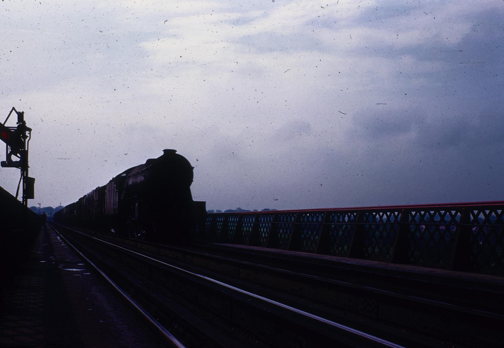 Steam locomotive on approach to Forth Bridge with freight