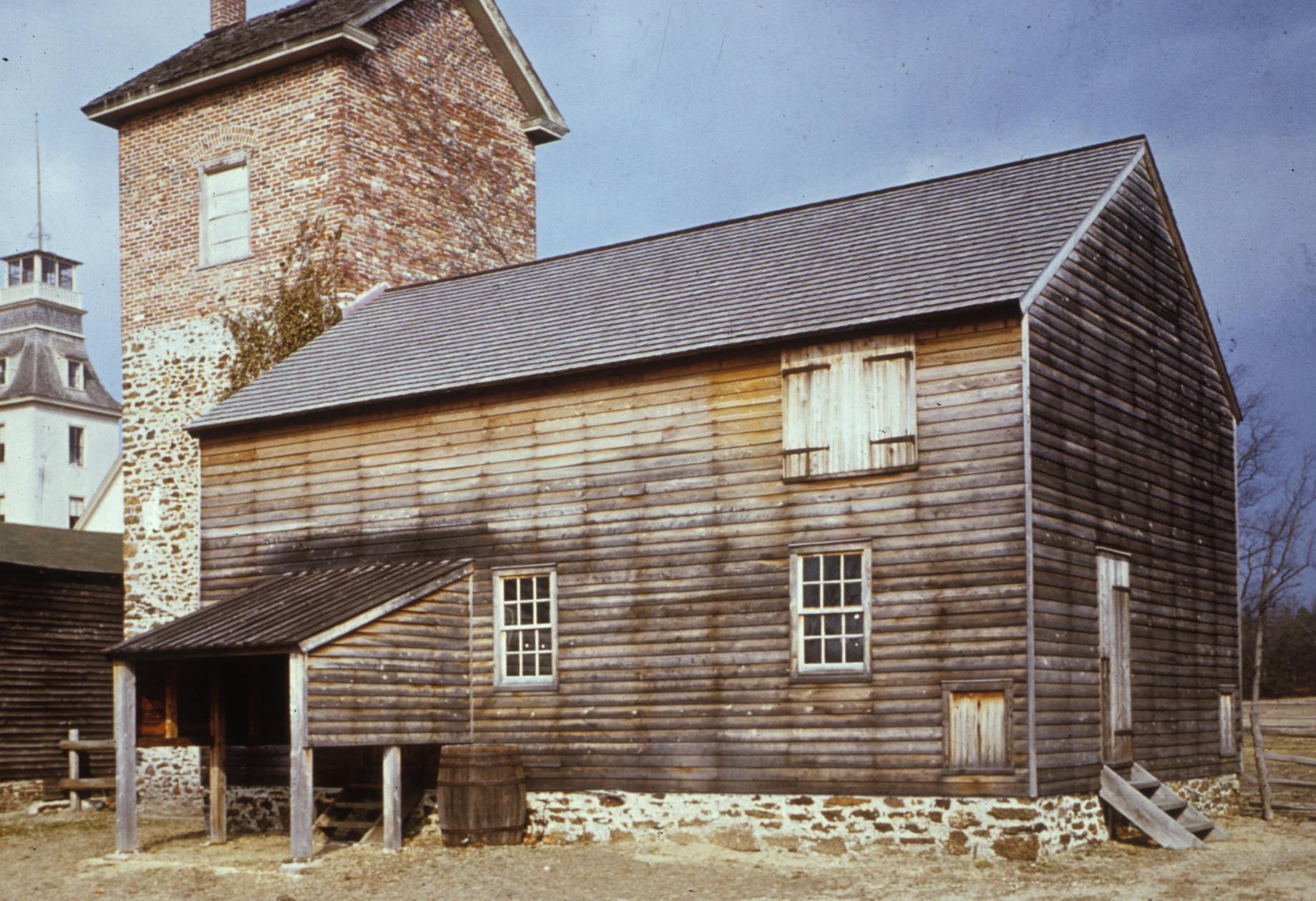 Wood-sided piggery structure with adjacent brick water tower