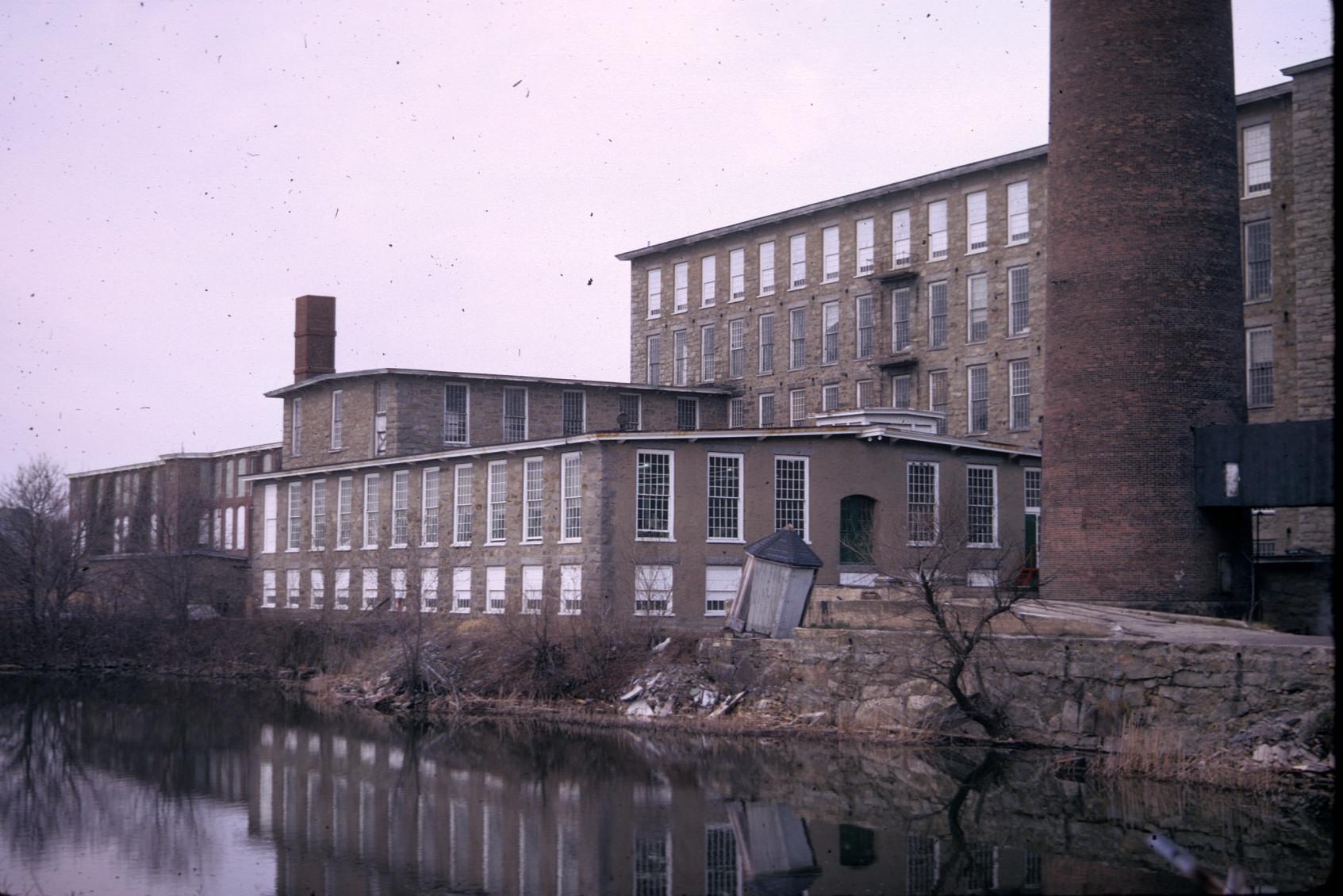 Riverside view of King Philip Mills.  Two stacks visible.  