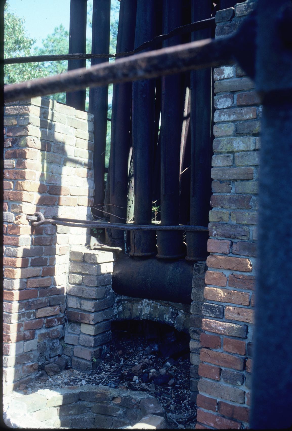 View at top of furnace showing piping for hot-blast and furnce charging hole.