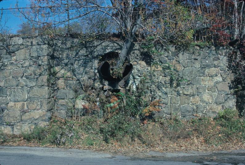 Stone wall with cross section of embedded penstock pipe (Note: also visible…