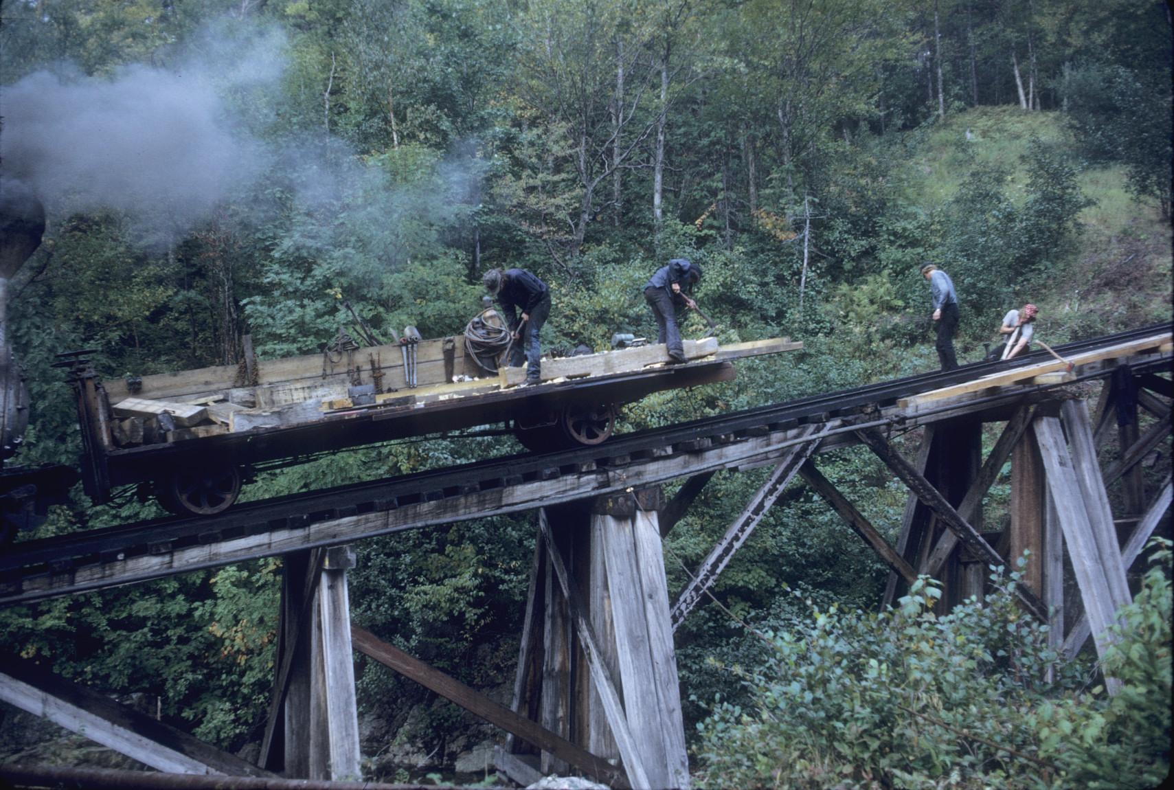 Work crew unloading timbers on elevated track above Base station