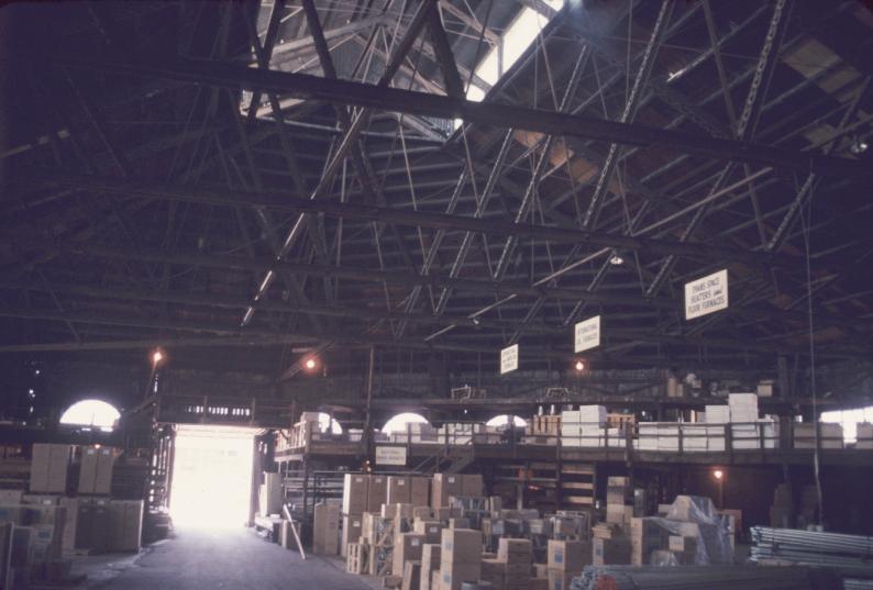 Interior view of former rolling mill building, apparently used for storage.