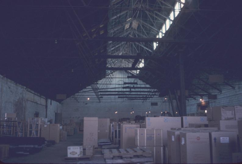 Interior view of former rolling mill building, apparently used for storage.