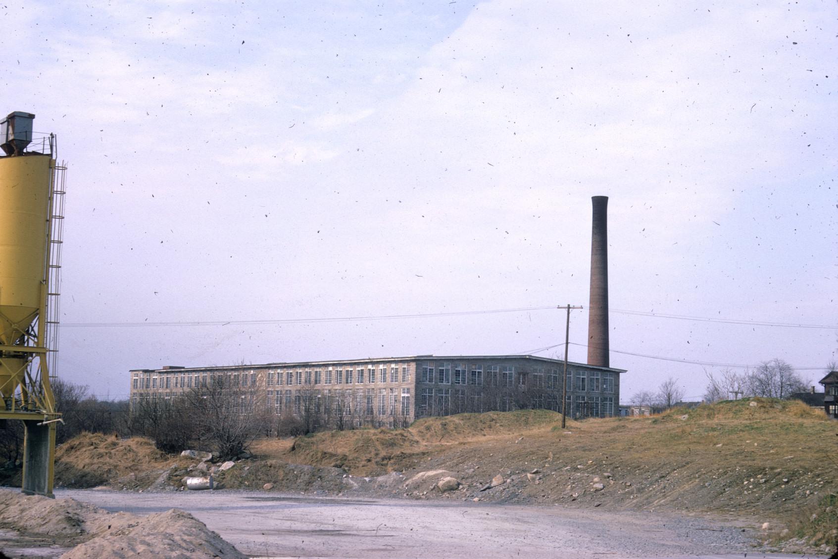 Distant view of the Charlton Mill.  Stack visible.  Note the wide construction…