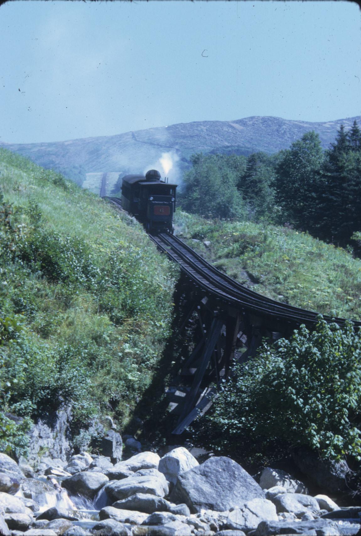 Train on slop beyond low timber trestle