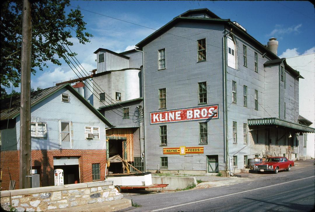 says \"Kline Bros\" and \"Wayne Feeds\" on side of building