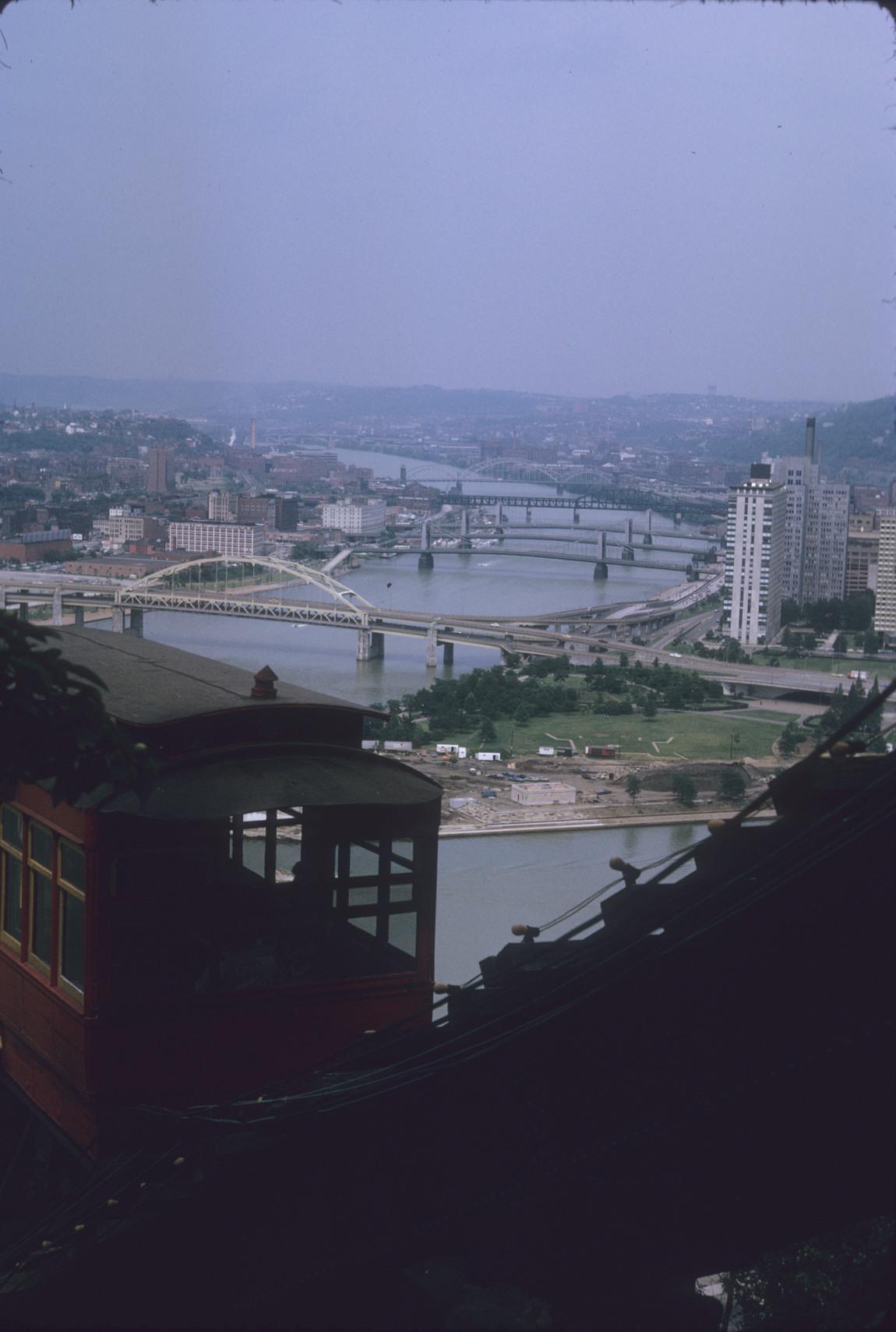 View of car on track from below track structure; Downtown Pittsburgh and…