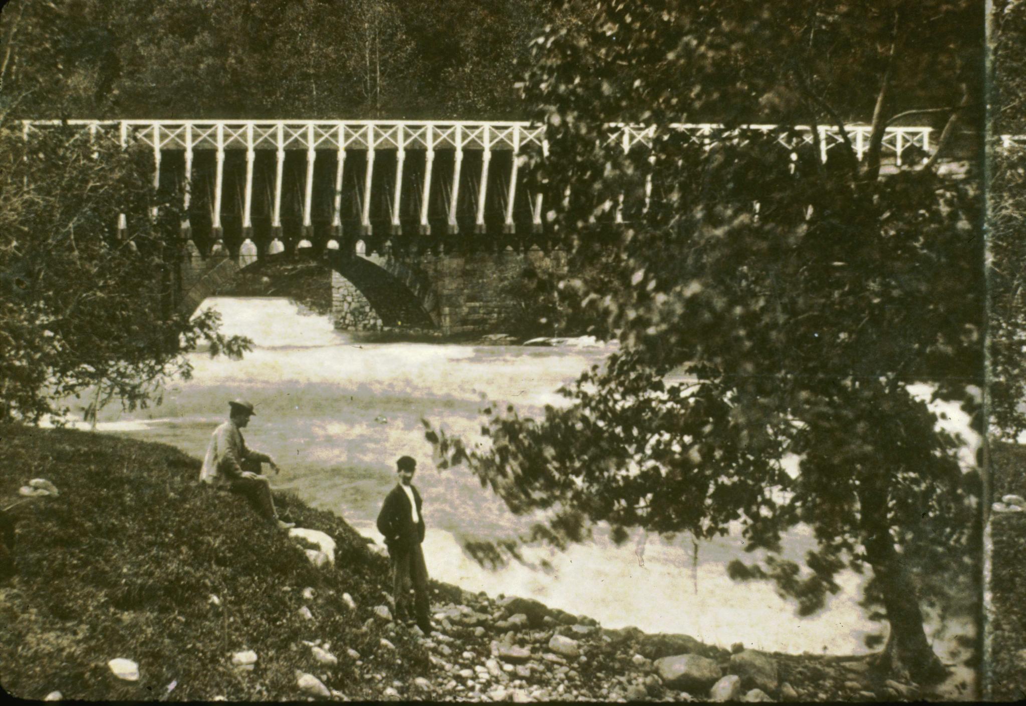 Historic photograph of the High Falls Aqueduct.  Two men in foreground.The…