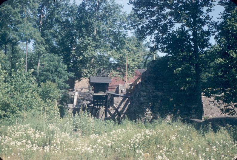 Distant view showing relationship of blowing engine and water wheel to furnace