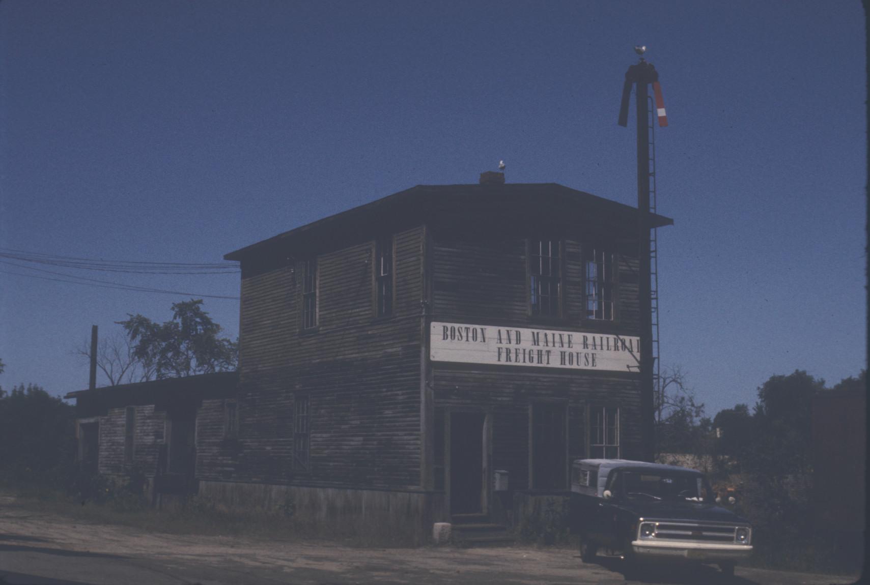 Wooden freight house with seagulls on roof, semaphore signal