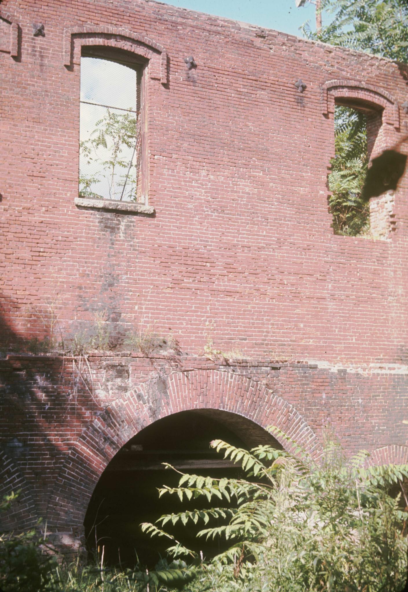 Photograph of the ruins and brick tailrace arches of an unidentified mill on…