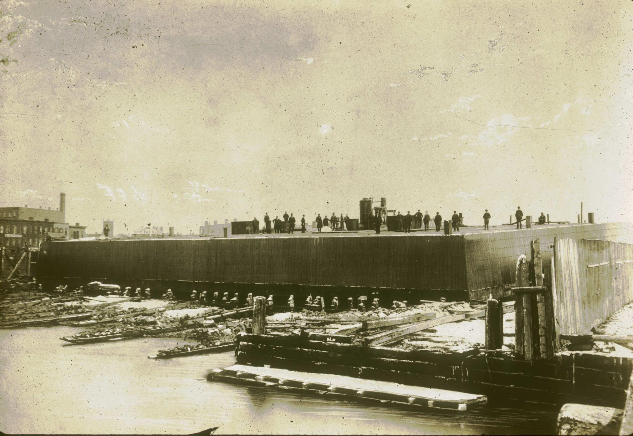 Historic photograph of the launch of one of the Brooklyn Bridge caissons.  