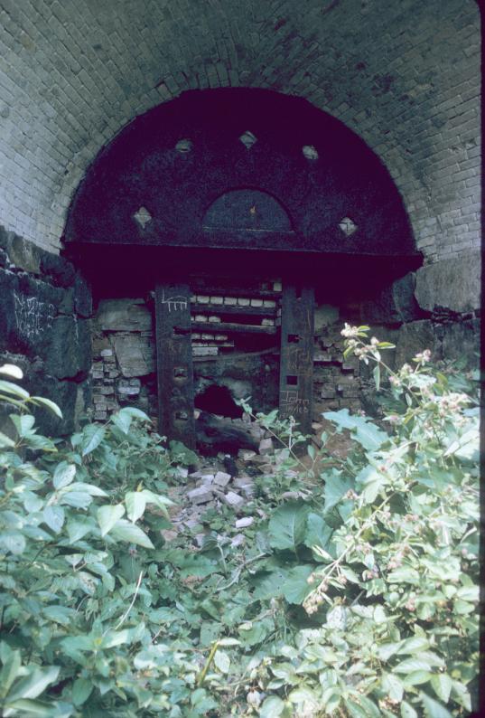 View of brick furnace arch with metal gate.