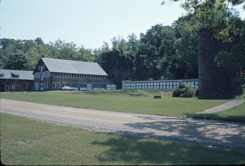 View of furnace complex, with furnace, sheds, other structures, and stone silo…