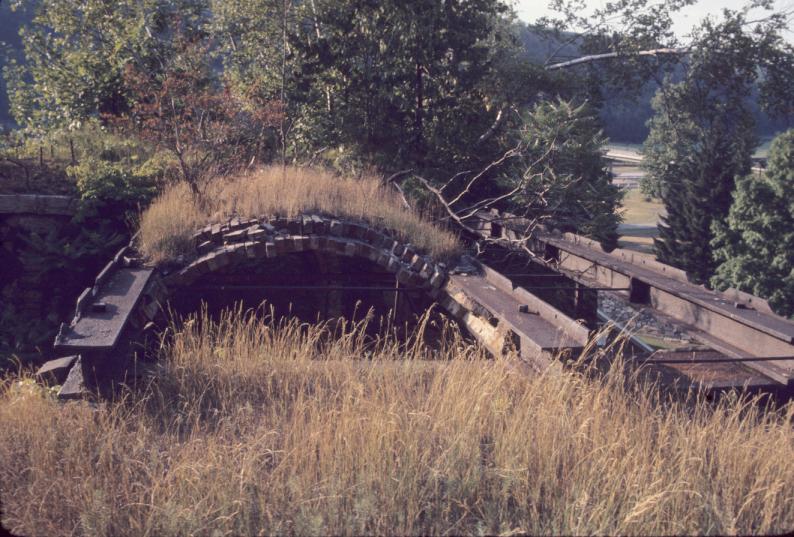 View across metal frame remains of bridge to furnace charging deck.