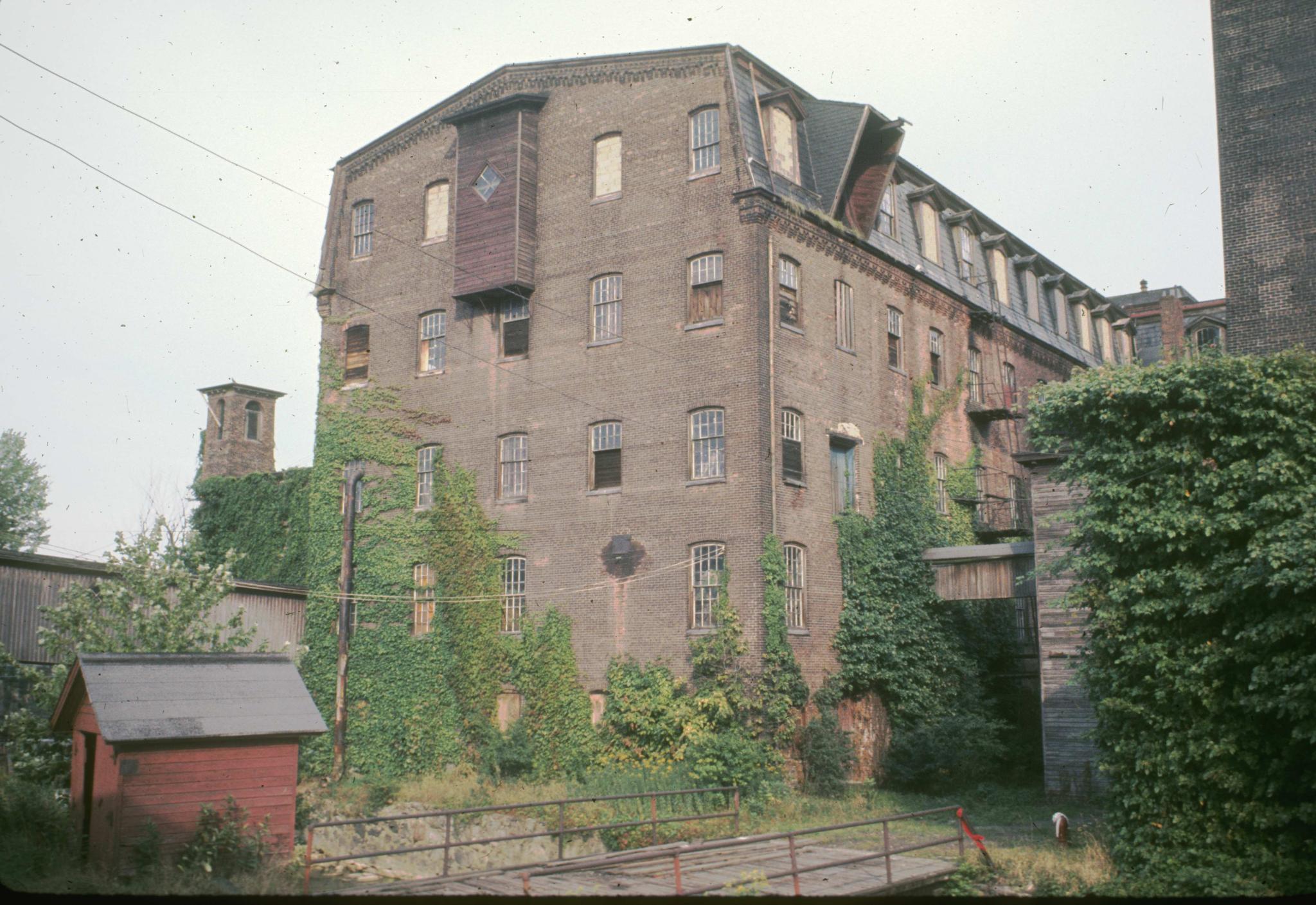 Photograph of the side of the mill.  A small canal lies in the foreground.