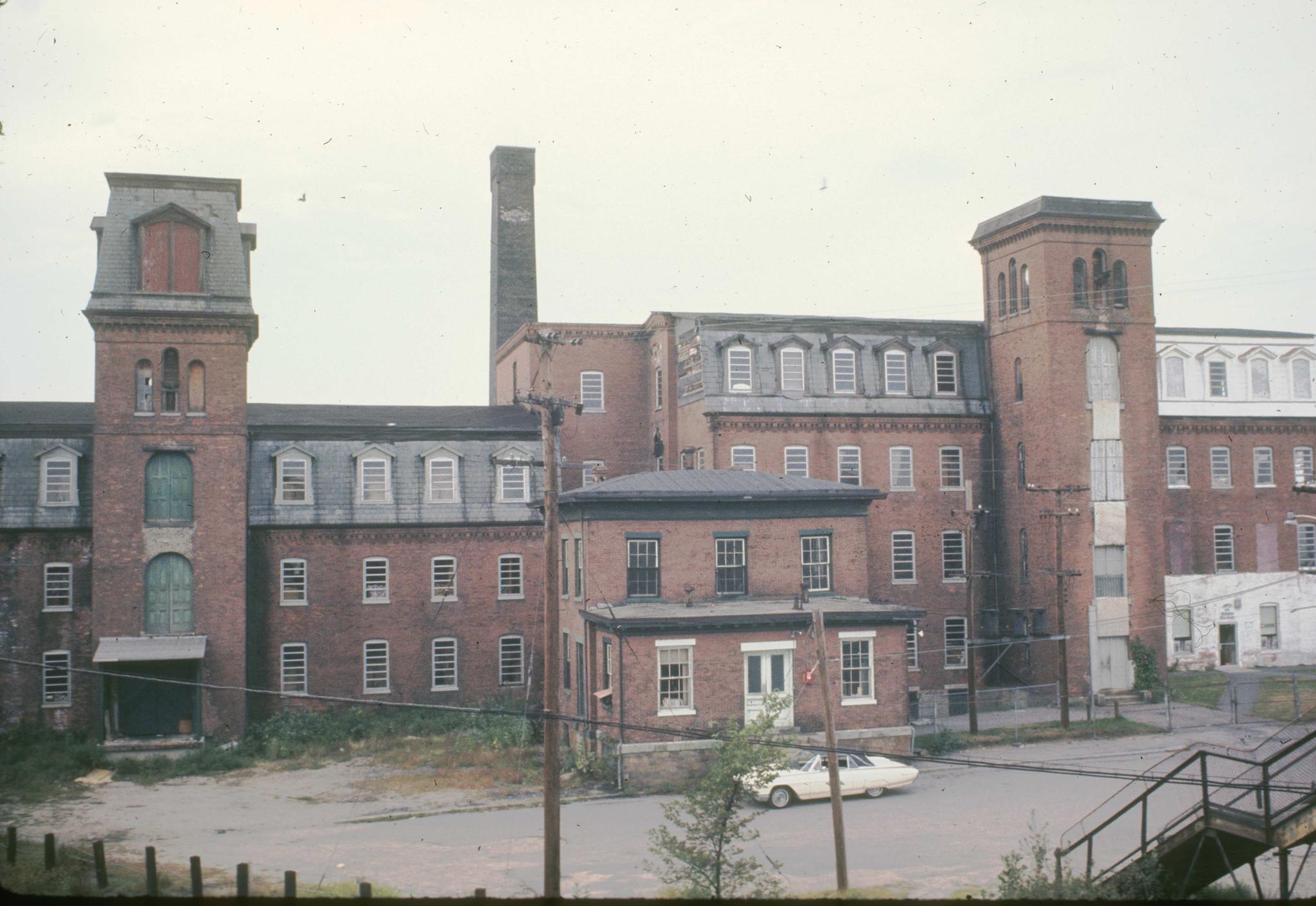 Photograph of two connected mill buildings and smaller office (?) building to…