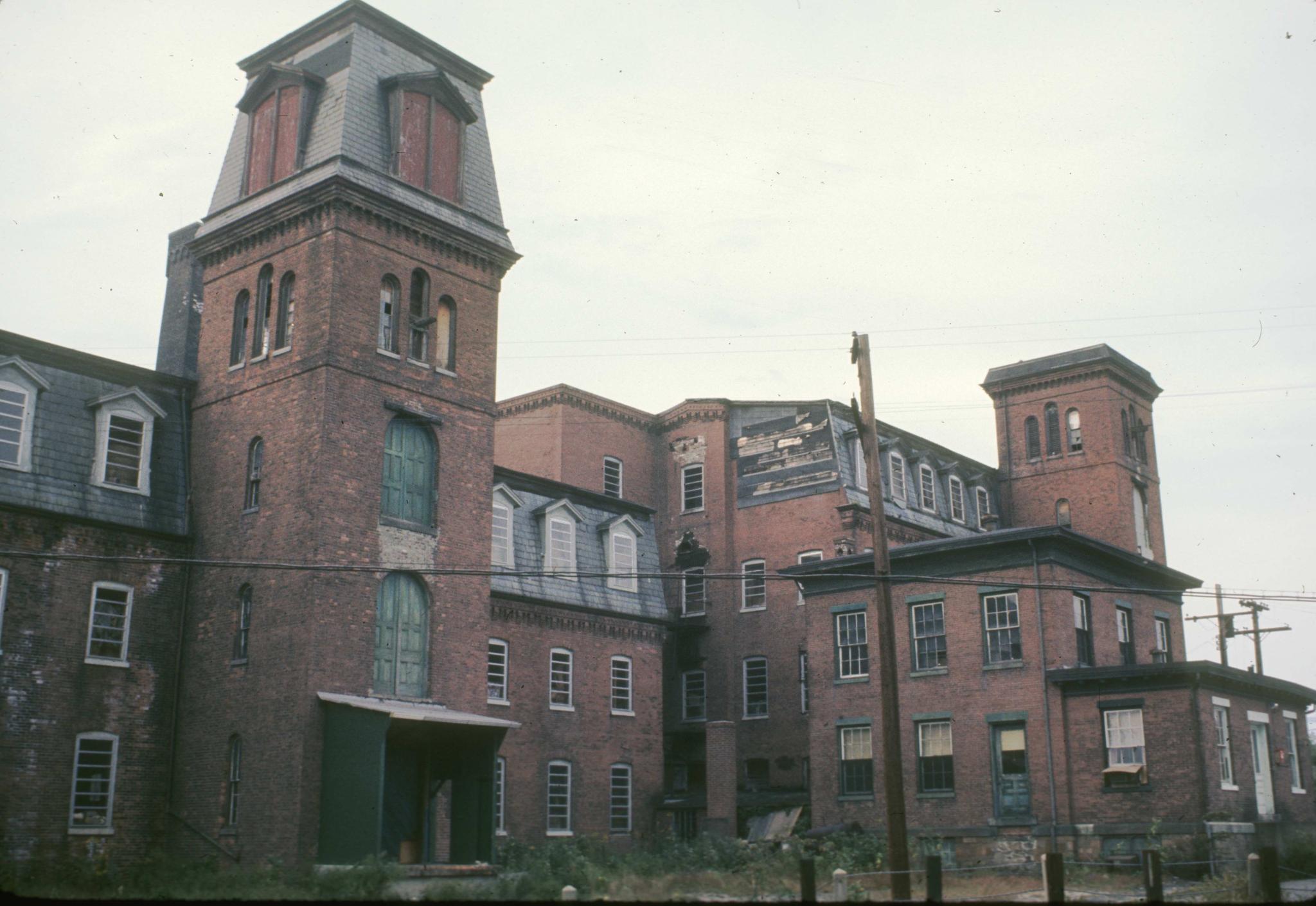 Photograph of the main mill buildings and office (?) building.