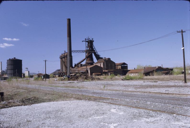 View of ca. 1925 blast furnace and complex, as well as railroad tracks and…