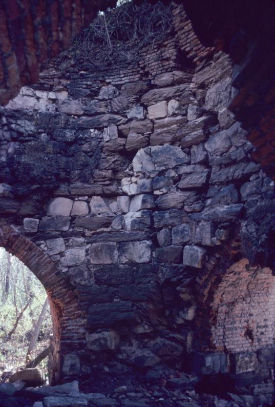 View of interior of masonry blast furnace with brick arches.