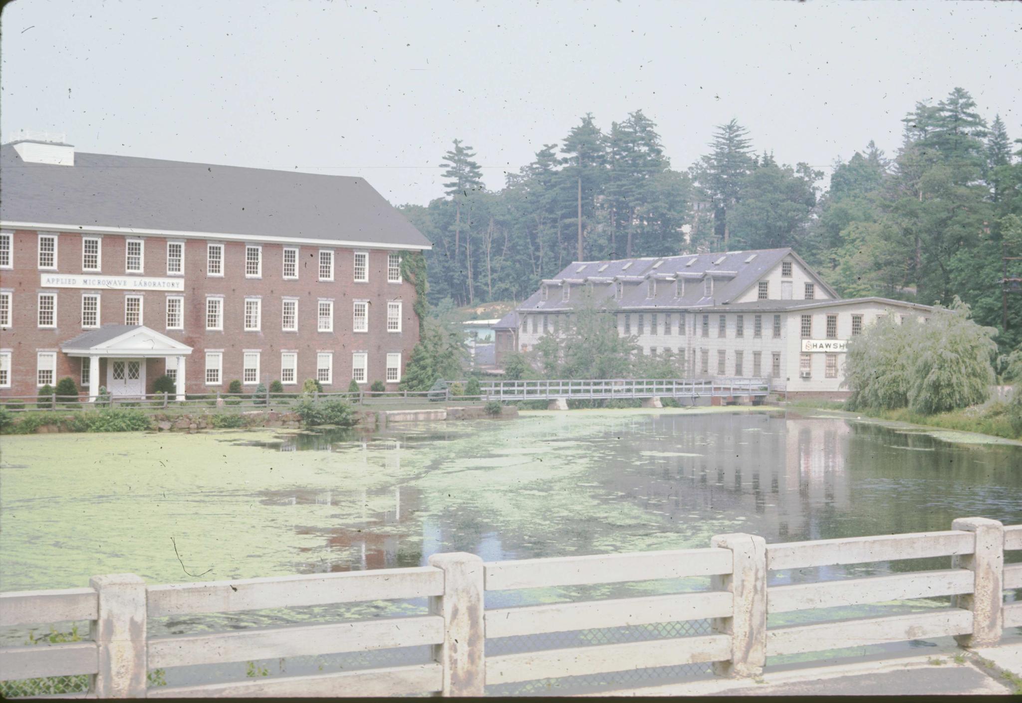 Photograph of the mill with the mill pond in the foreground.