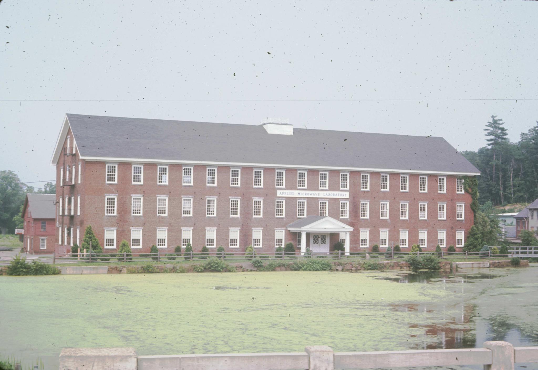 Photograph of the main mill building with the mill pond in the foreground.