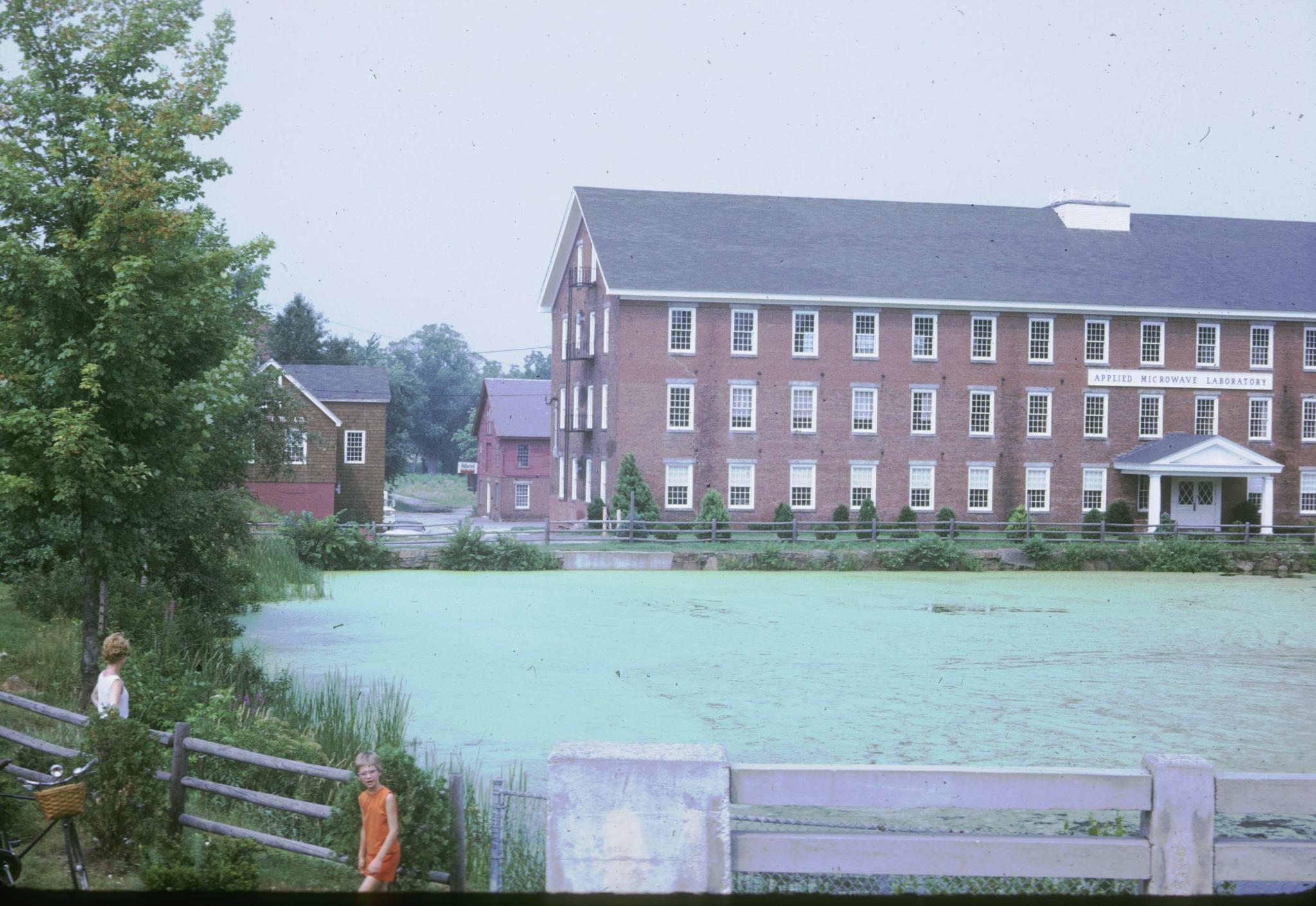 Photograph of the main mill building with the mill pond in the foreground.