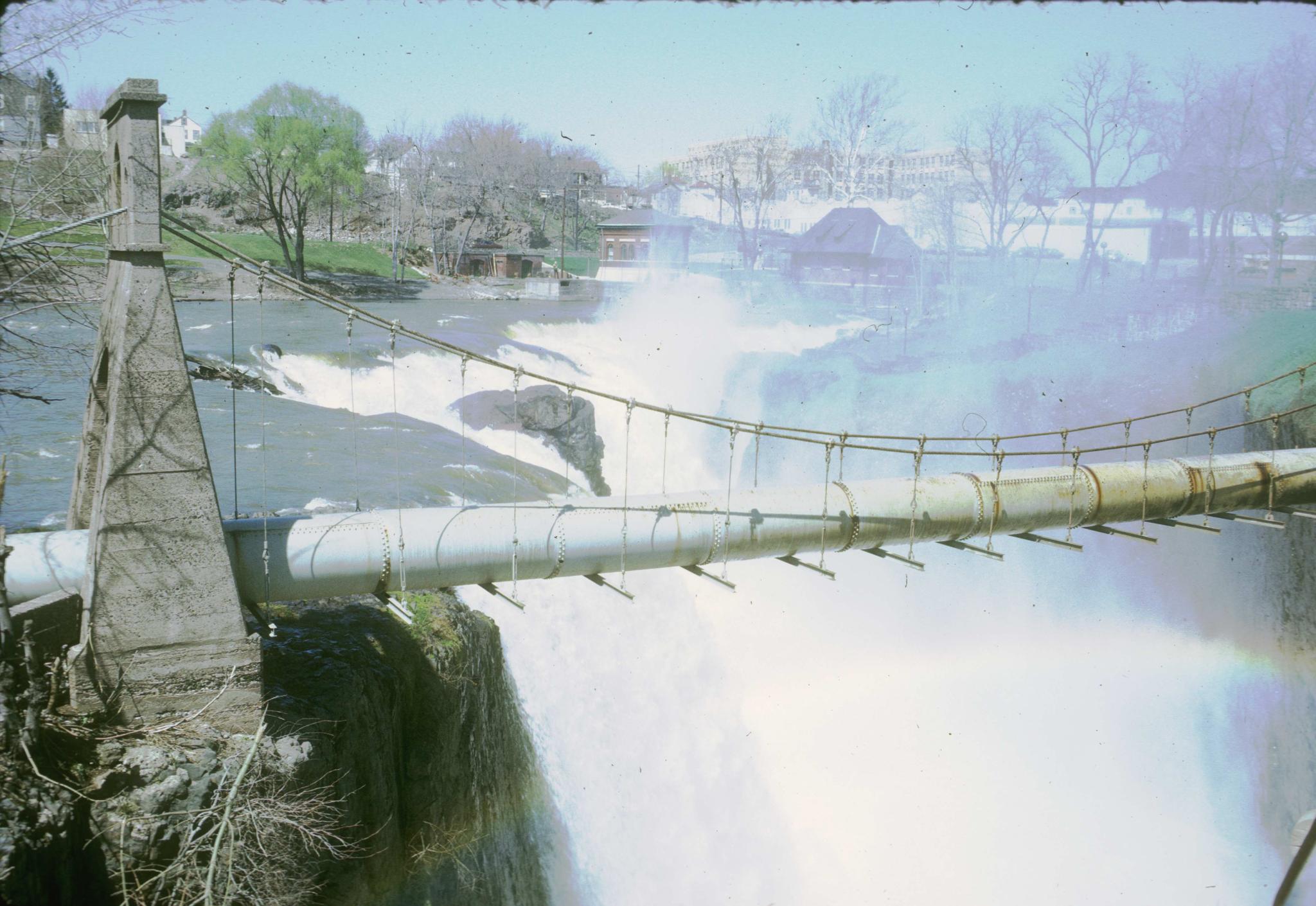 Photograph of an unidentified pipe suspension bridge crossing the Passaic Falls…