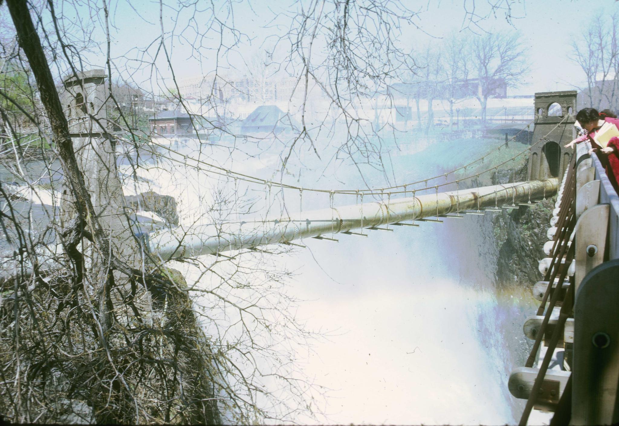 Photograph of an unidentified pipe suspension bridge crossing the Passaic Falls…