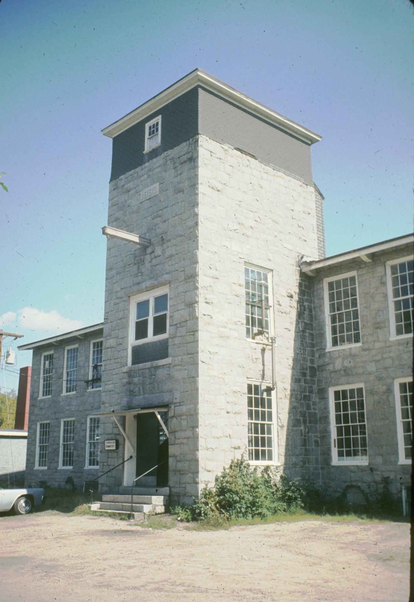 Photograph of the mill showing the tower.  Date of 1883 is shown over the…