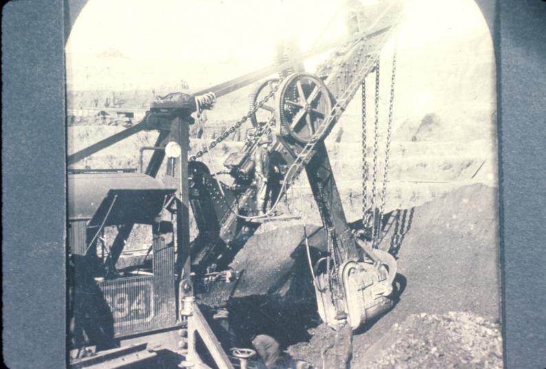 Photograph of a steamshovel excavating ore from an unidentified location in the…