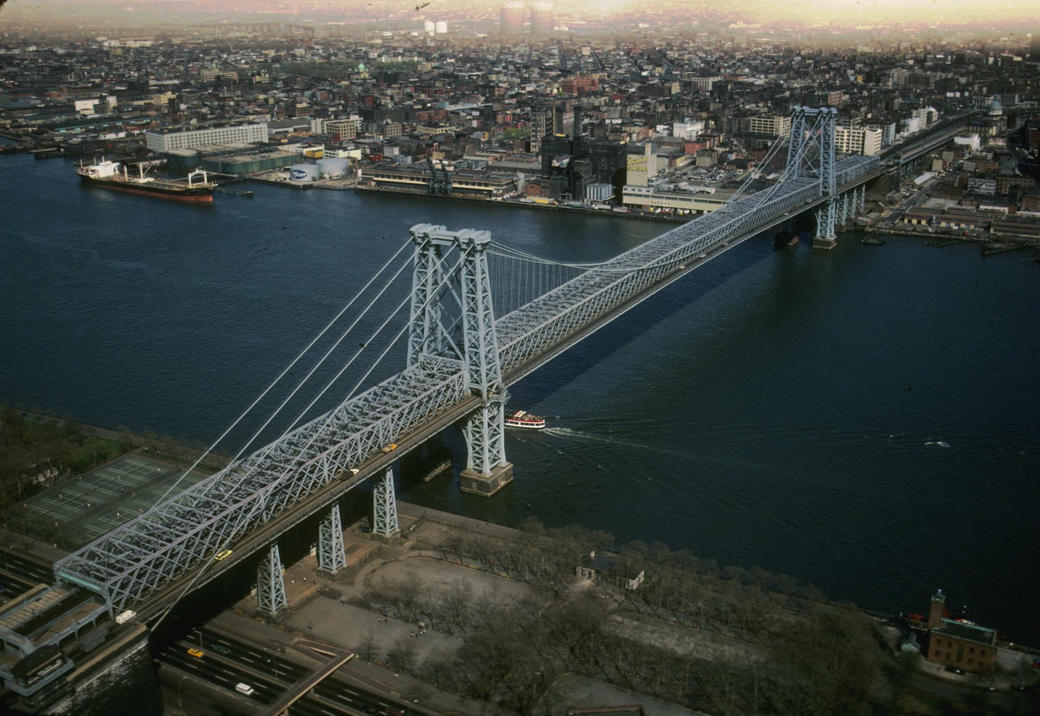 Aerial photograph of the Williamsburg Bridge.  An ocean-going freighter is…