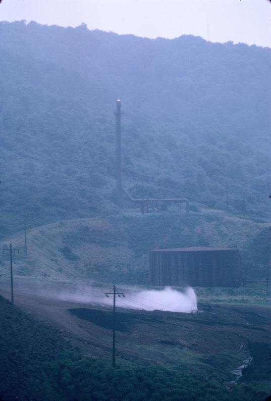 Photograph of isolated metal stack, large metal storage tank, and a water jet…