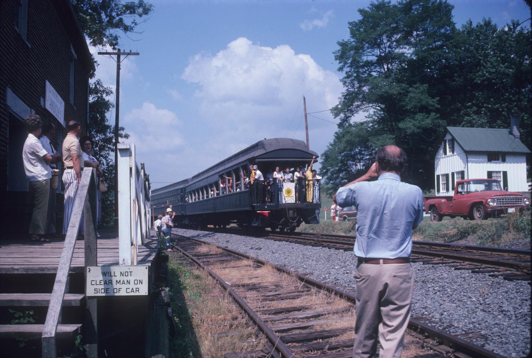 Train departing stationJohn H. \"Jack\" White, Jr. in foreground