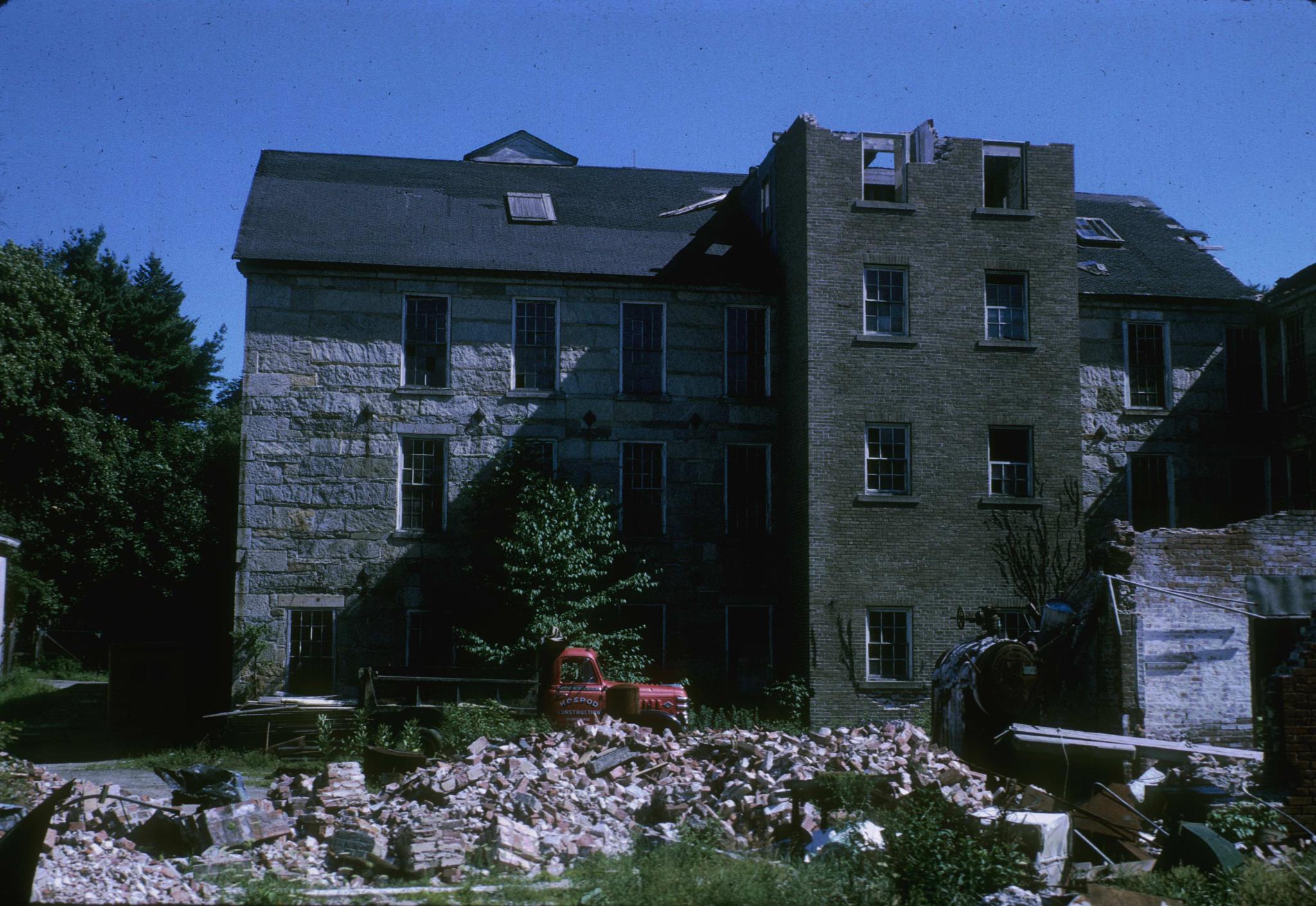 Photograph of a ruined mill near Saundersville, Massachusetts.  A boiler and a…