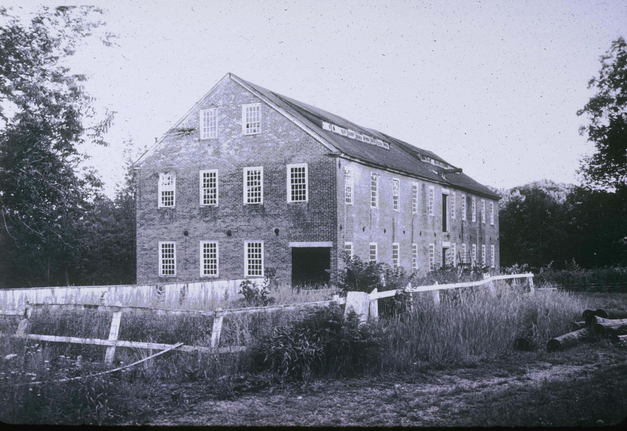 Black and white photograph of an unidentified brick mill in North Uxbridge,…