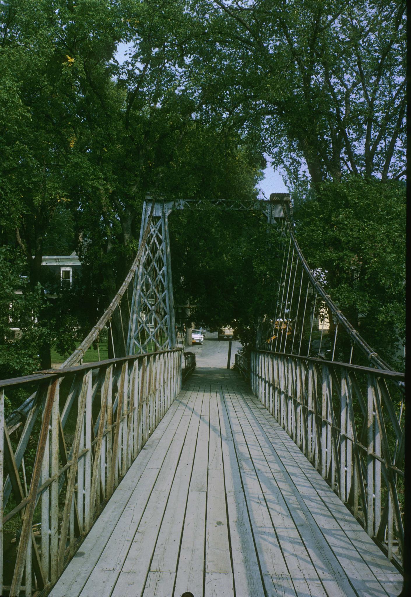 Photograph along the deck of the Keeseville Suspension Bridge with a good view…