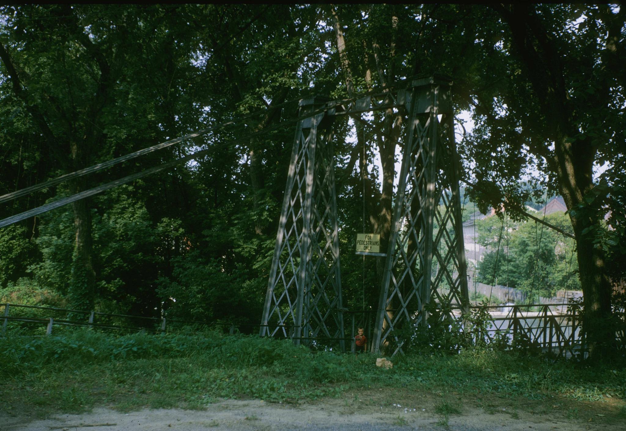 Photograph of a support tower of the bridge.  A small boy is in the photograph.