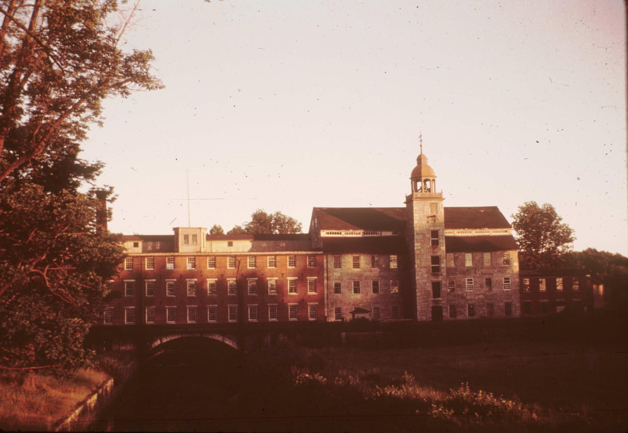 Photograph of the Crown Mill and connecting structure.  The slide is…