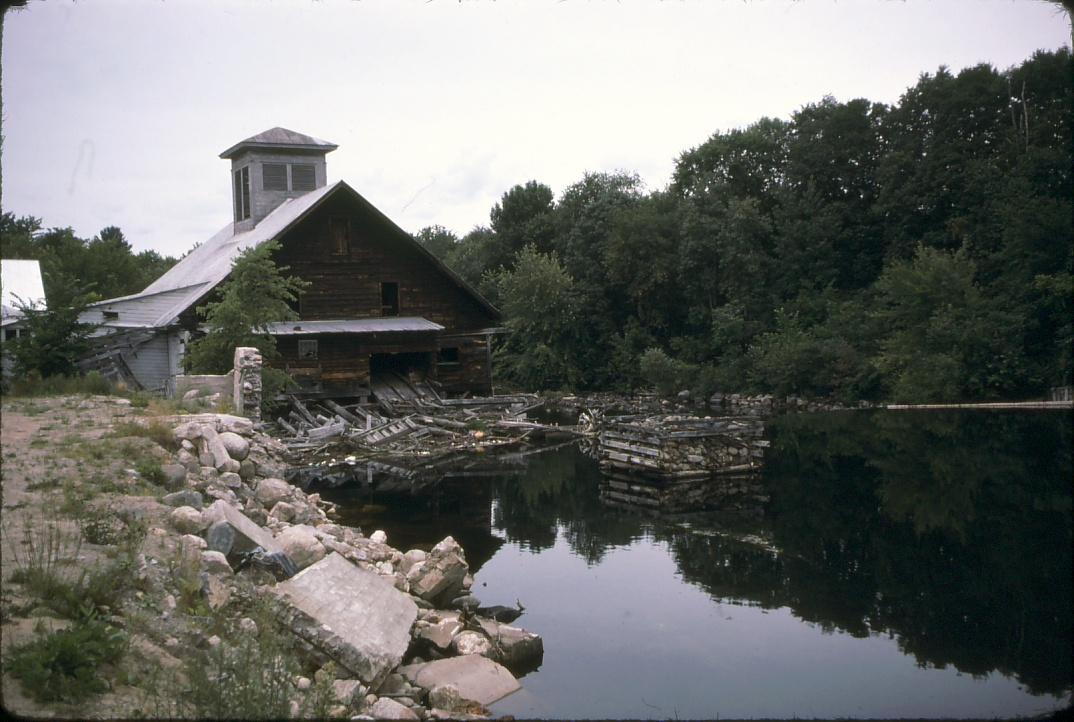 View of A.C. Emerson Saw mill and log boom pier in the Schroon River.  Also…