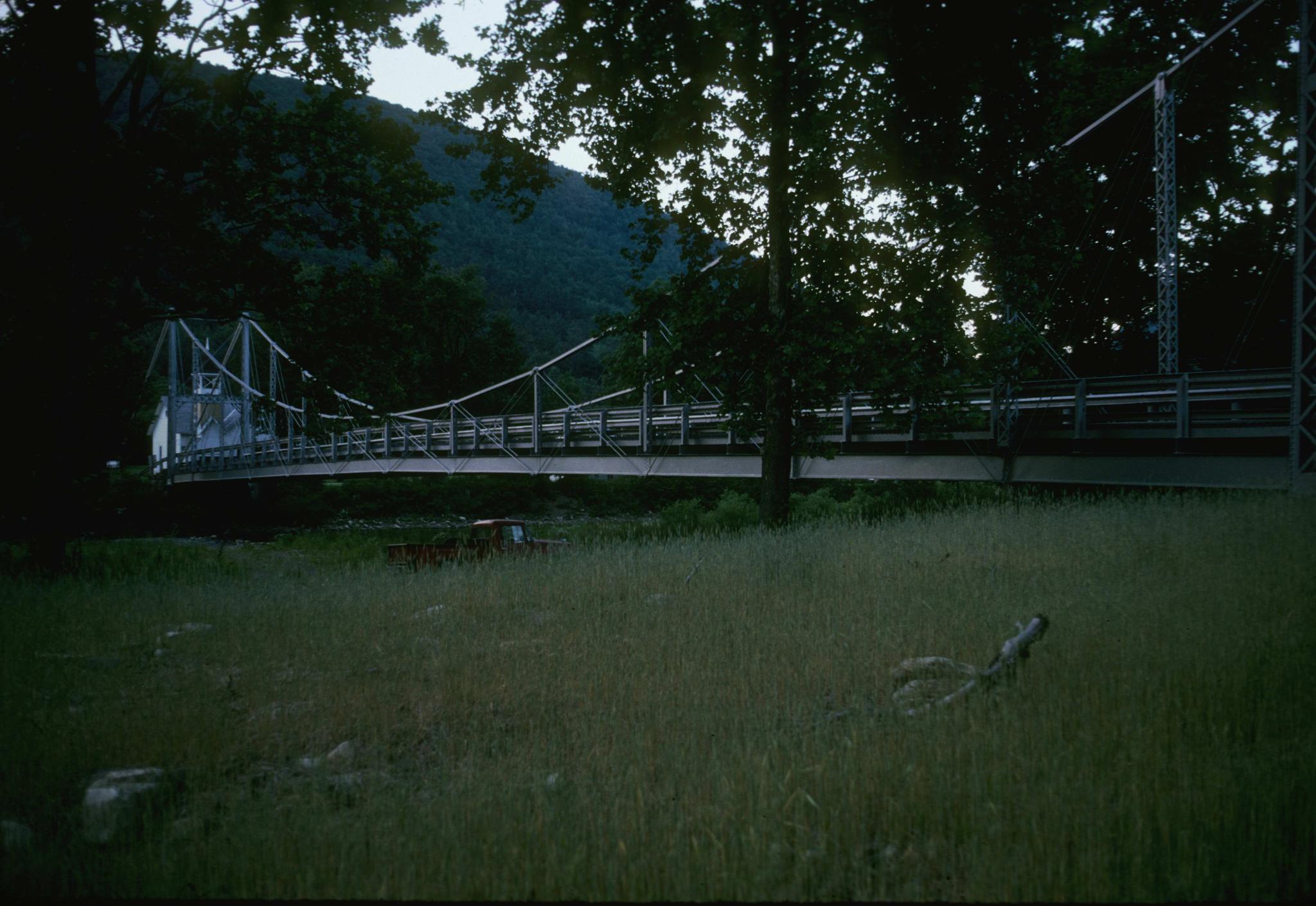 Photograph of the bridge showing a pick-up truck parked just to its side.