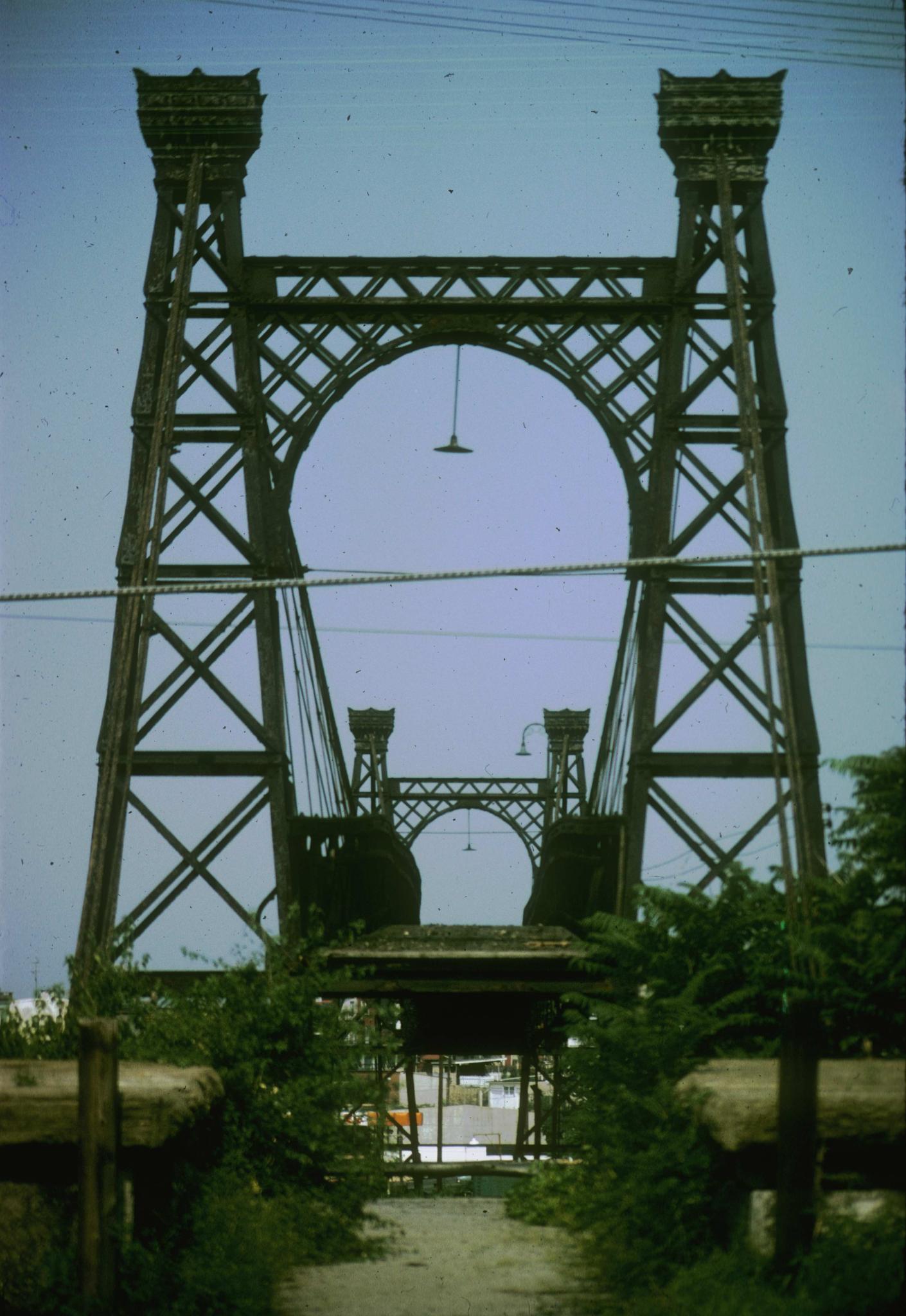 Photograph along the deck of the bridge taken from an anchorage.